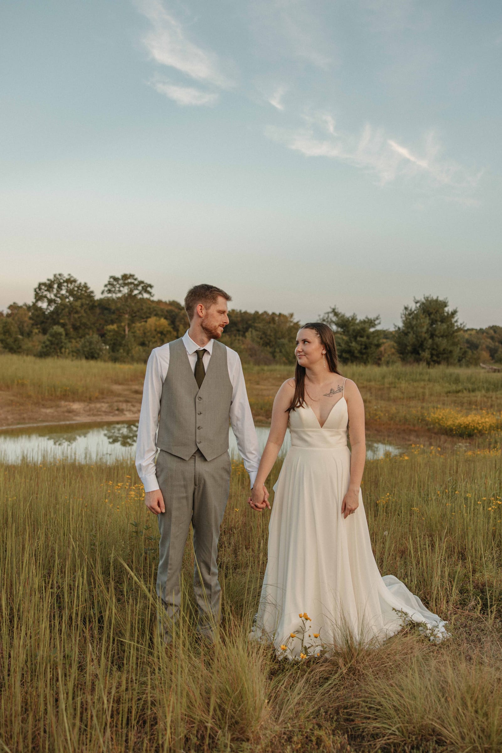 Bride and groom in the meadow at golden hour