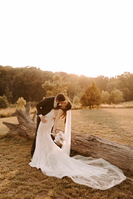 Couple portrait on the driftwood log in the ceremony meadow at Cedar Hills Farm