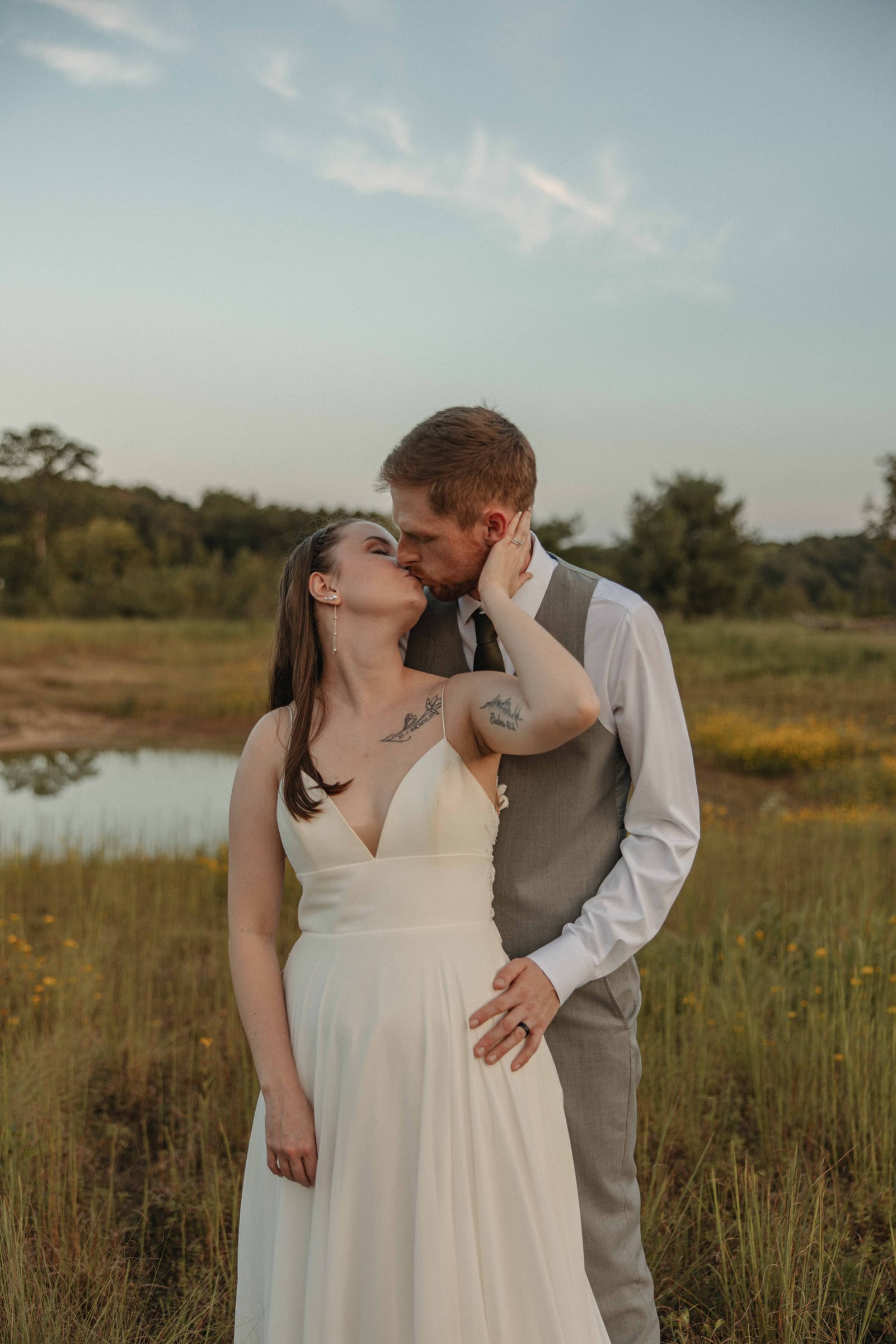 Couple sharing a kiss at golden hour in the meadow