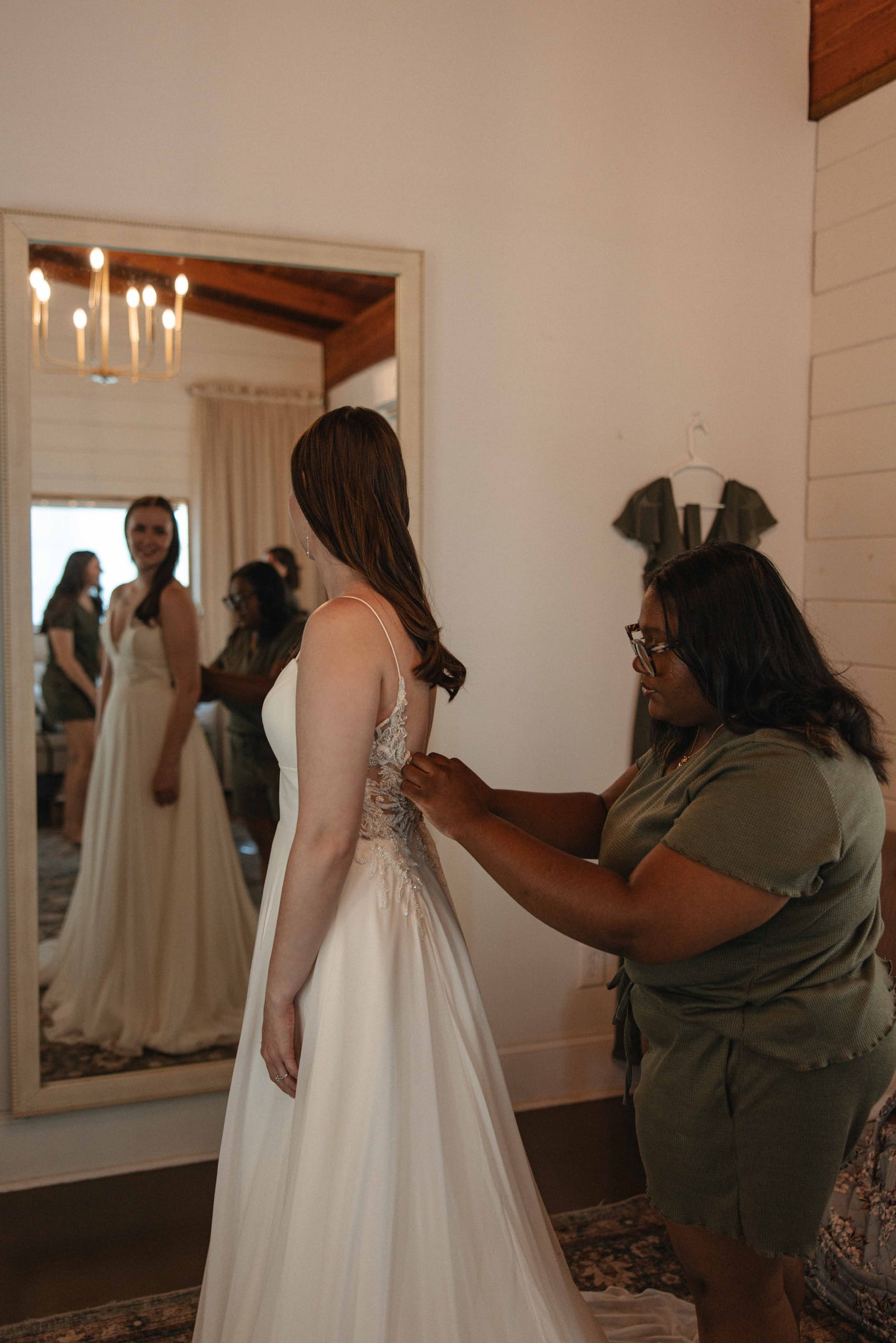 Bride getting her dress fastened in the bridal suite at Cedar Hills Farm